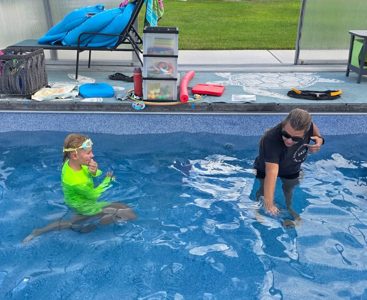 A Silverpoint Aquatics instructor demonstrating a water skill for a young swimmer